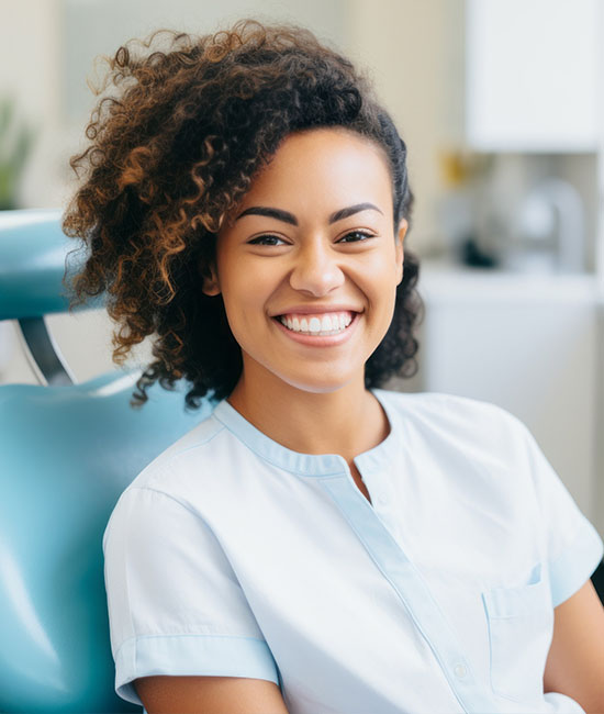 A woman with a radiant smile receiving dental care while sitting in a dental chair.